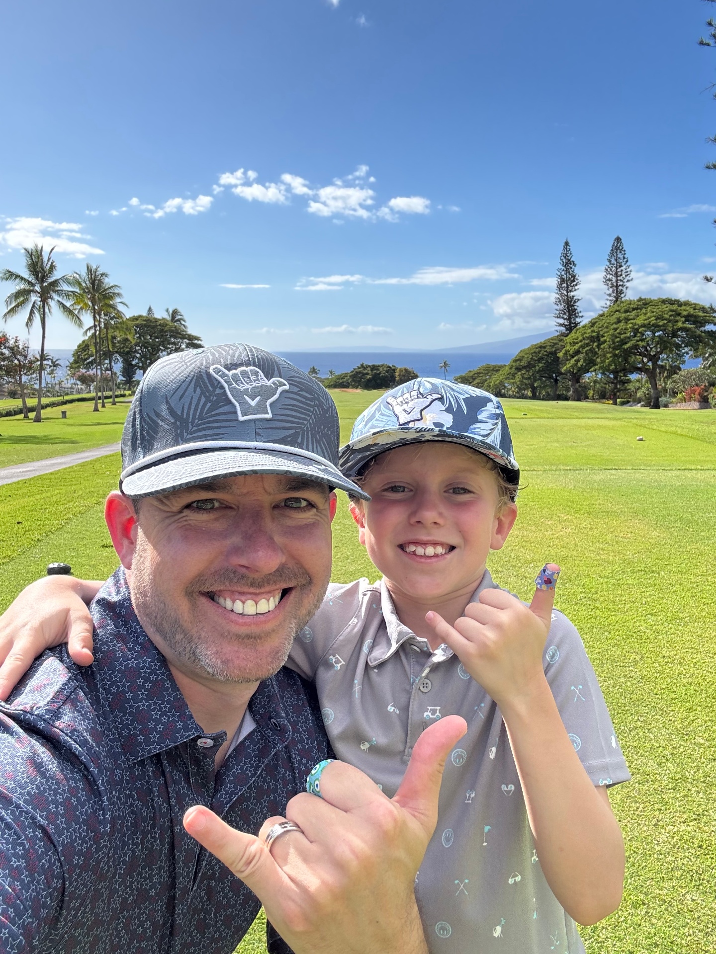 Nick and Hunter throwing shakas on a Hawaii course